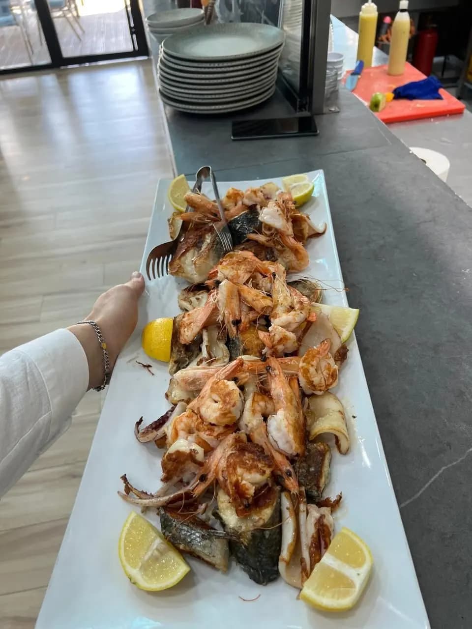 Pjatë e gjatë me karkaleca dhe peshk, e servirur me limon